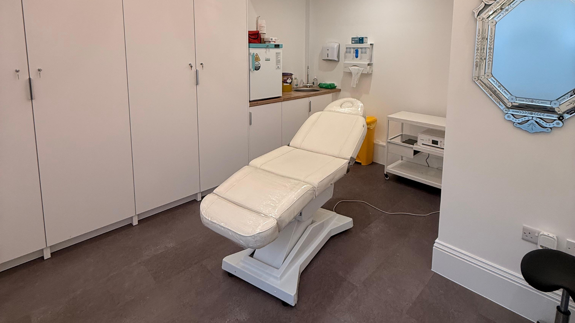 Modern, fully equipped treatment room with an adjustable treatment bed, creating a clean, comfortable and professional environment for beauty treatments.